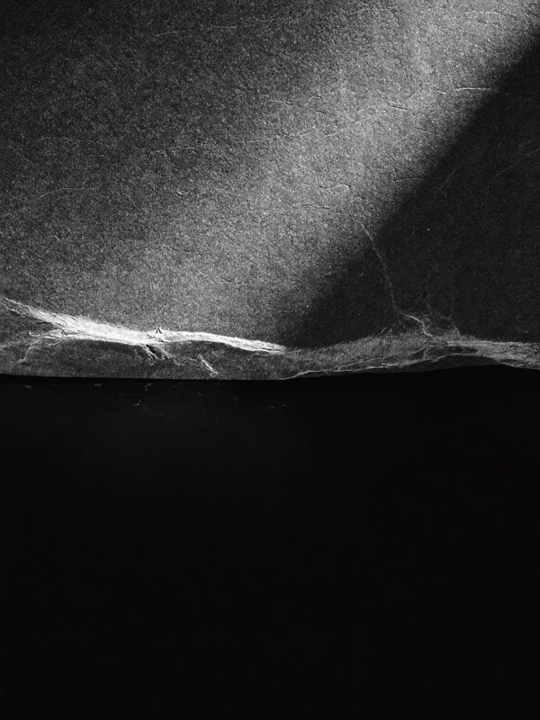 Dark textured stone surface lit from one side