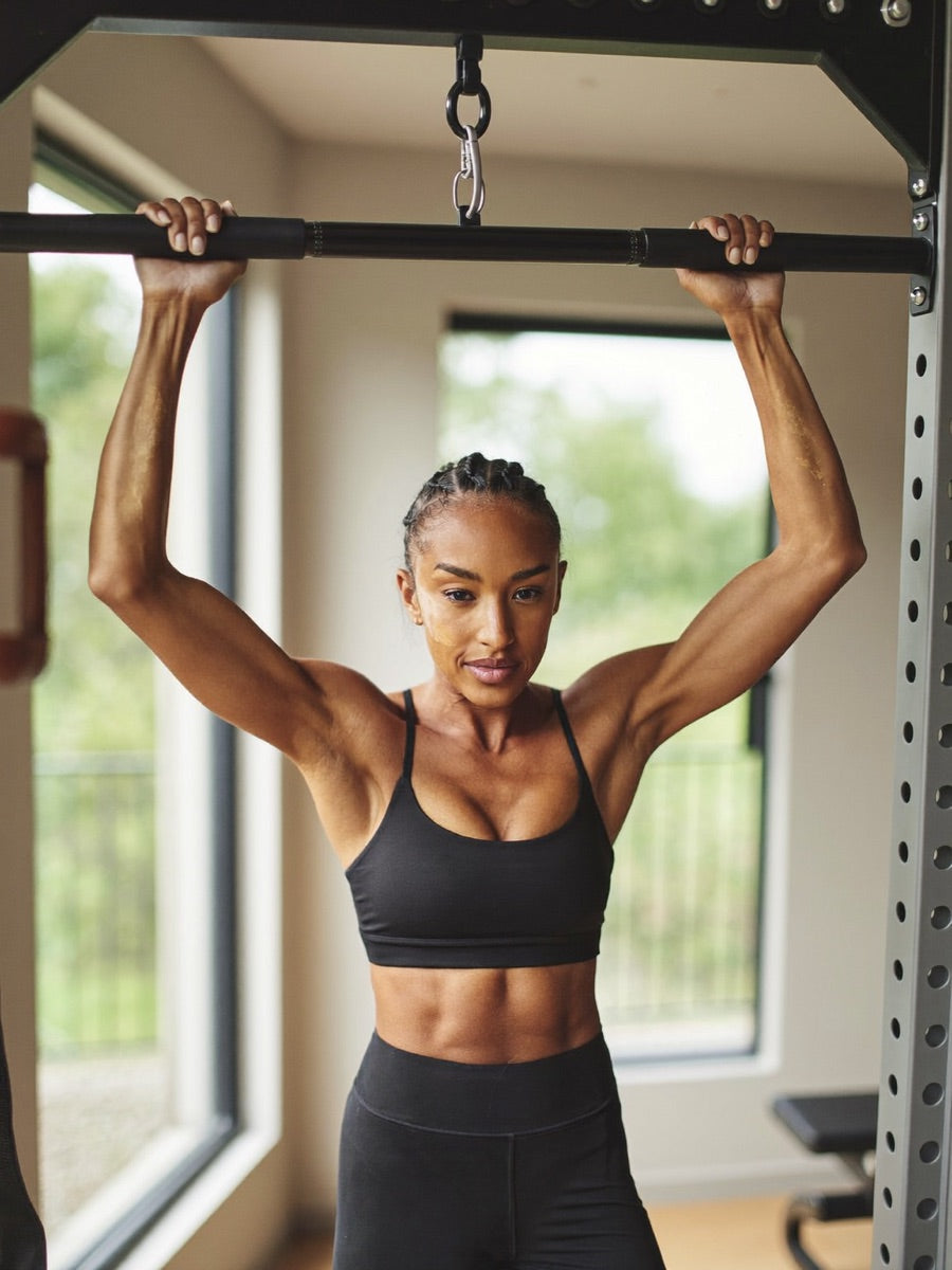 Woman in her mid 30s training at a squat rack